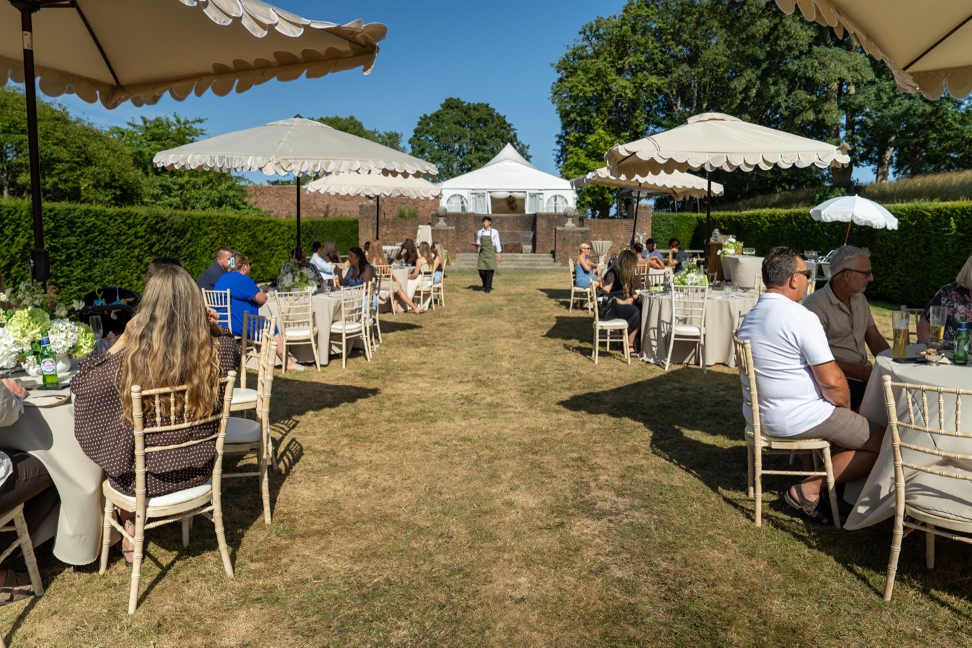 Long tables and parasols in the walled garden